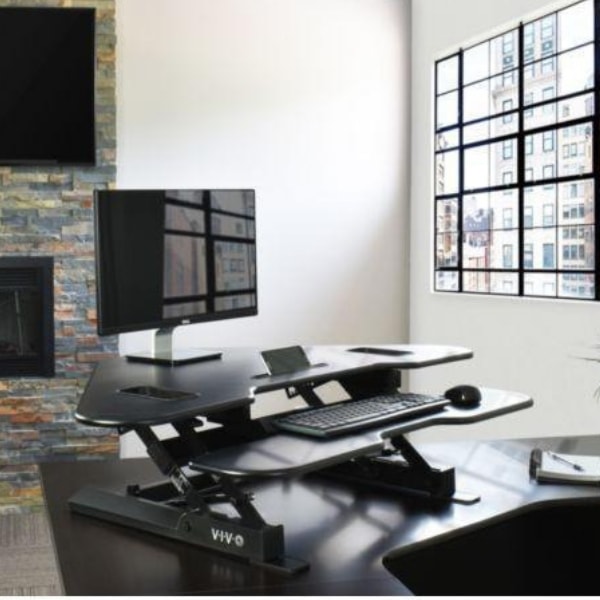 VIVO DESK-V000C Corner Standing Desk Converter On A Office Desk